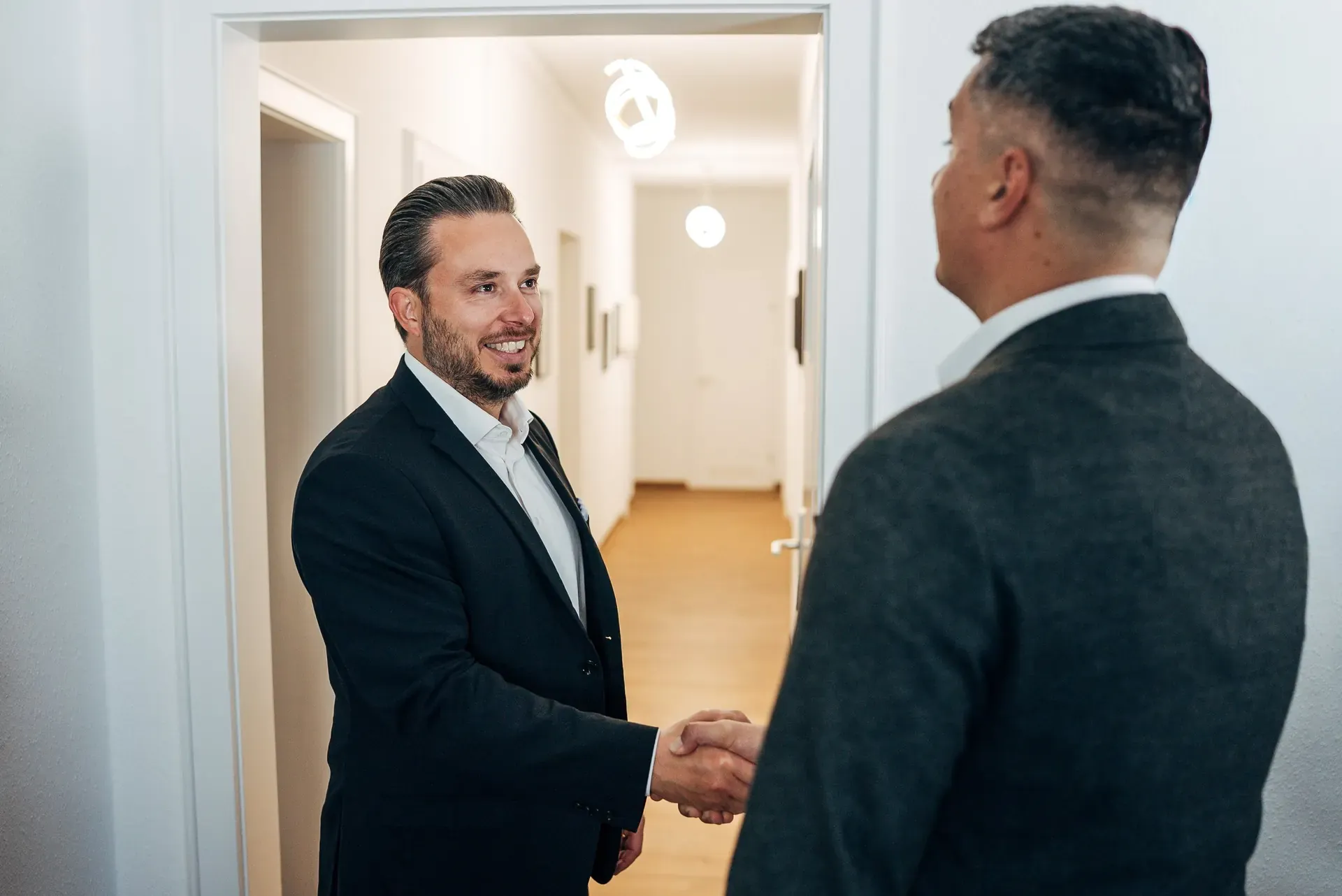 Philipp Blobel begrüßt einen Mandanten mit Handschlag im Büro
