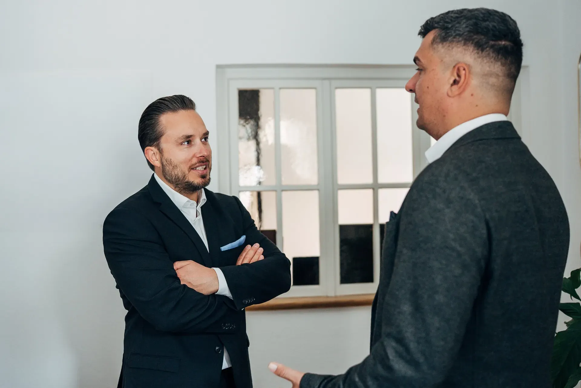 Philipp Blobel und ein Mandant im Beratungsgespräch am Fenster