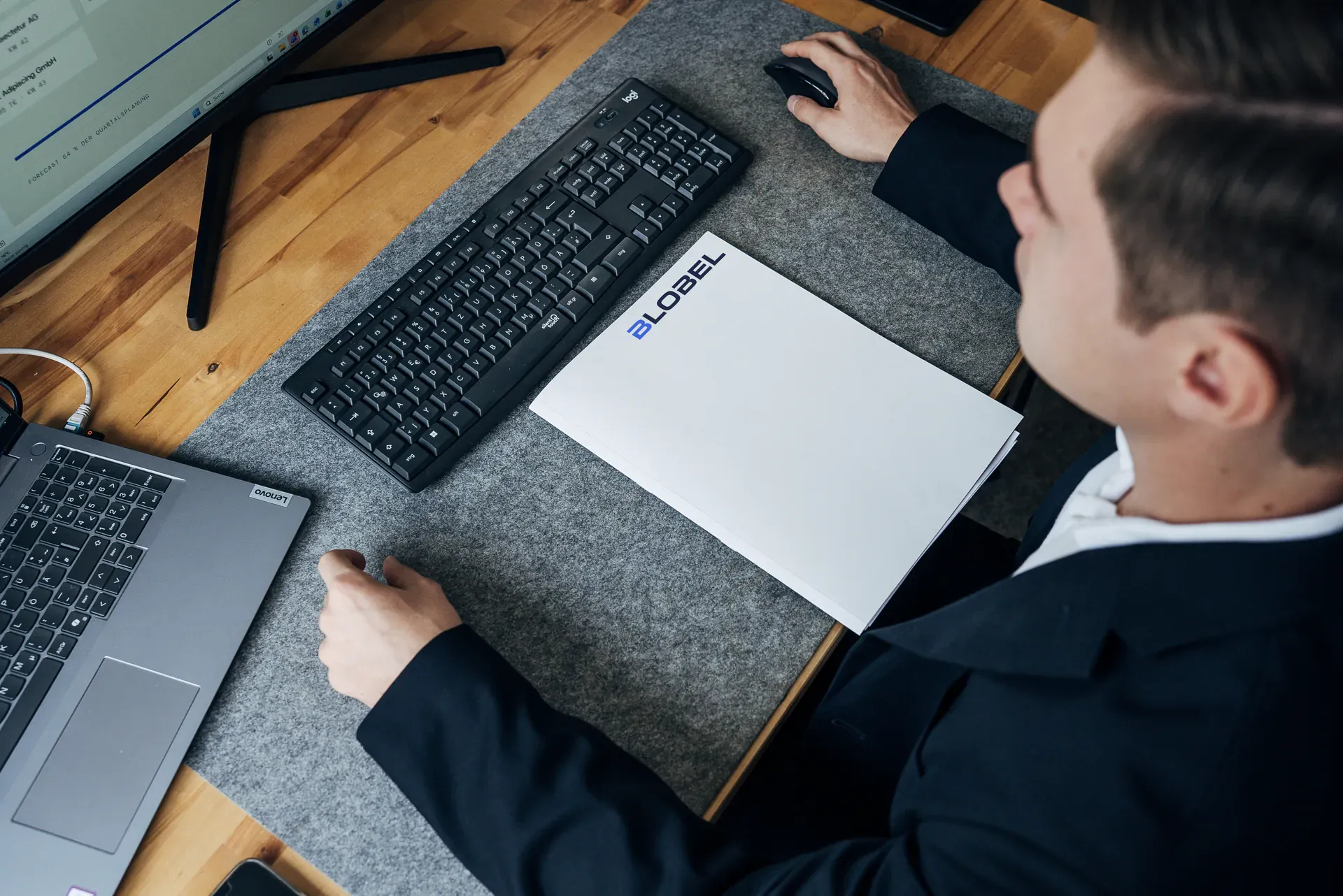 Berater von Blobel Consulting am Schreibtisch mit Unterlagen im Blobel-Design